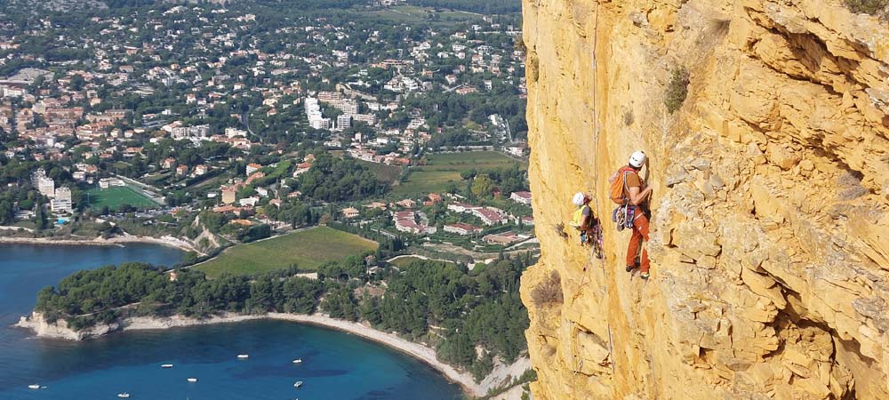 le moniteur regarde ses élèves escalader en tête